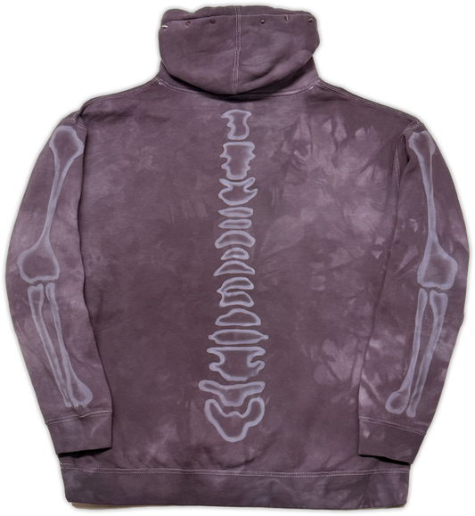 A purple tie-dye hoodie shown from the back, featuring a white graphic of a human spine running down the center and white skeletal arm and leg illustrations on both sleeves.