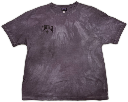 A short-sleeve crewneck t-shirt with a dark purple and gray mineral wash, featuring a black 'CONTRAST' graphic printed on the left chest.