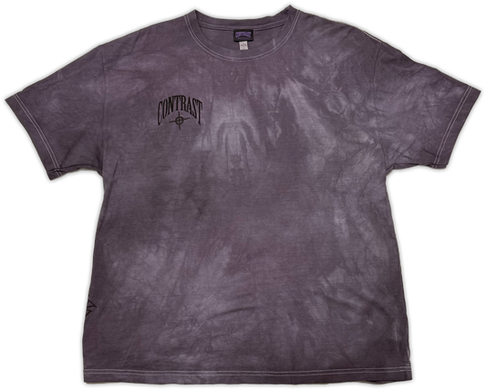A short-sleeve crewneck t-shirt with a dark purple and gray mineral wash, featuring a black 'CONTRAST' graphic printed on the left chest.