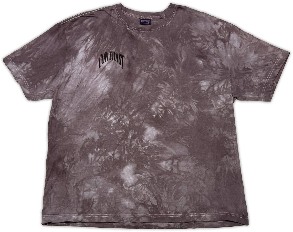 A short-sleeve crewneck t-shirt featuring a dark gray and white tie-dye pattern, with the word 'CONTRAST' printed in a stylized black font on the left chest.