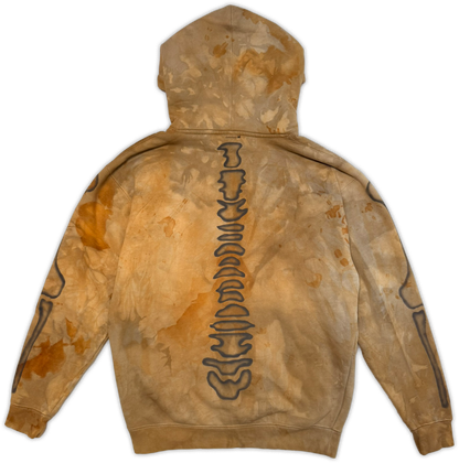 A hooded sweatshirt shown from the back, featuring a distressed tan and brown tie-dye pattern with a vertical spine graphic outlined in black down the center.