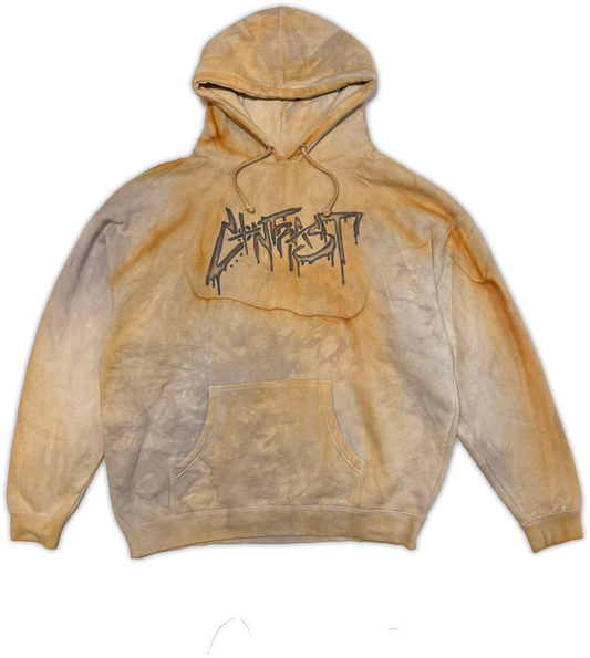 A faded natural rust dyed hoodie in a yellowish-brown and beige gradient, featuring a black graffiti-style 'CONTRAST' graphic printed across the chest.