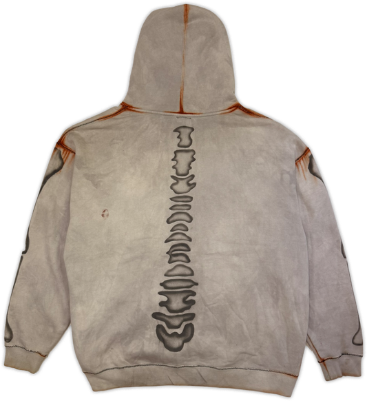 A light gray hooded sweatshirt shown from the back, featuring a large vertical black spine graphic down the center and distressed orange-brown stitched details along the hood, shoulders, and sleeves.