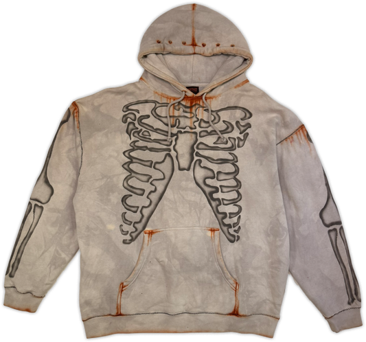 A light gray hooded sweatshirt featuring a large black rib cage graphic on the front, with distressed orange-brown rust accents and a faded, washed-out aesthetic.