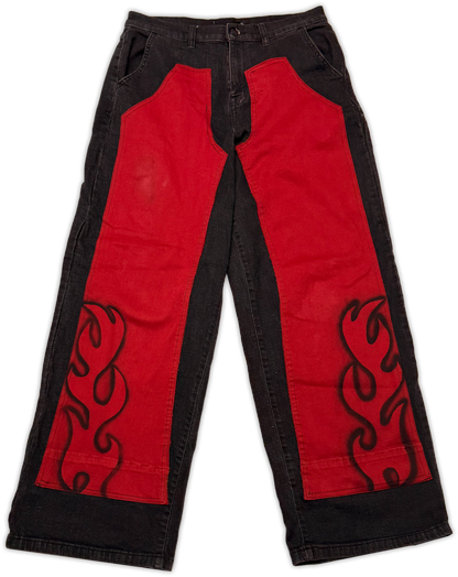 Red and black wide-leg pants with large red side panels and black flame-style embroidery on a white background.