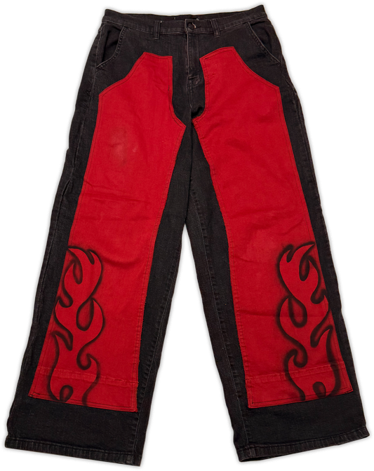 Red and black wide-leg pants with large red side panels and black flame-style embroidery on a white background.