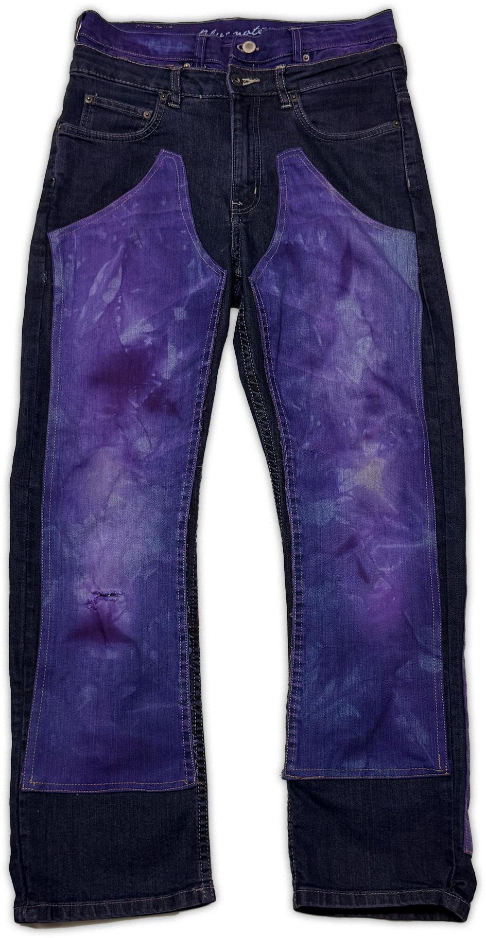 Dark blue denim jeans with large purple tie-dye patch panels on the front of both legs, shown flat against a white background.