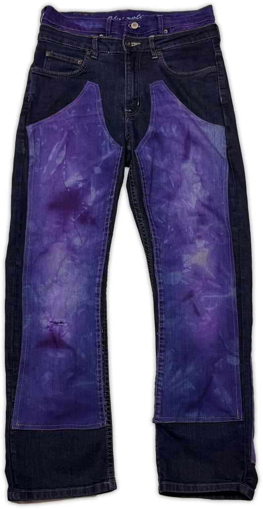 Dark blue denim jeans with large purple tie-dye patch panels on the front of both legs, shown flat against a white background.