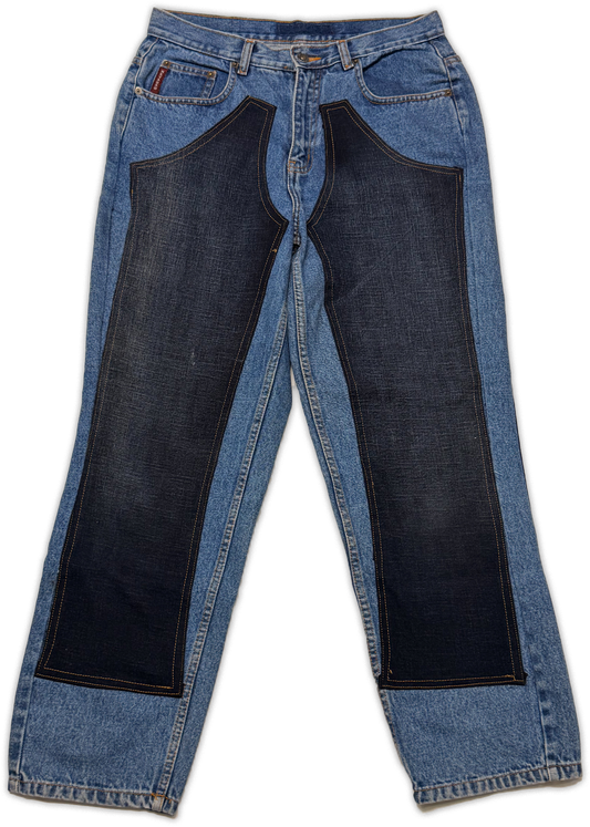 Light blue denim jeans with large dark navy patch panels on the front of each leg, shown flat against a white background.