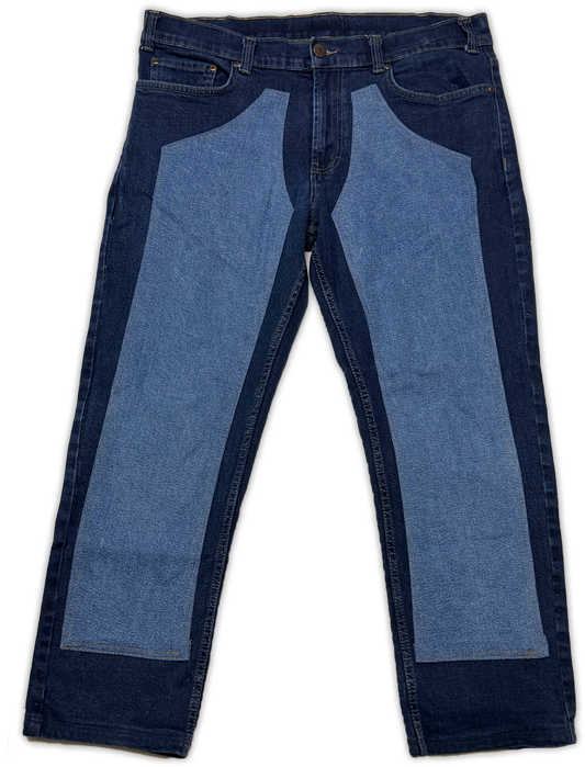 A pair of jeans with a unique dual-denim design, featuring dark blue denim side panels and light blue denim front thigh panels, shown flat against a white background.