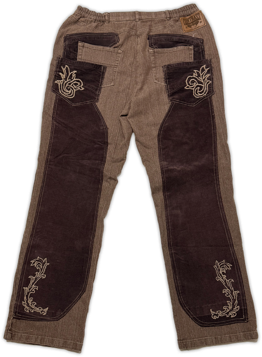 A pair of brown corduroy pants with dark brown suede-like knee patches and decorative beige embroidery, shown flat against a white background.