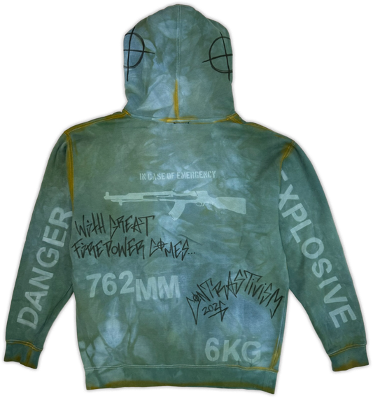 The back of a hooded sweatshirt with a green and blue tie-dye pattern, featuring white text and graphics including 'DANGER', 'EXPLOSIVE', '762MM', '6KG', and a rifle illustration with handwritten-style text.
