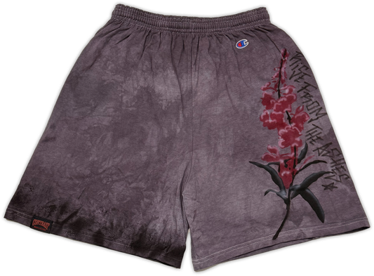 A pair of Champion athletic shorts in a dark gray and black tie-dye pattern, featuring a red and black fireweed graphic print on the right leg and a small Champion logo near the waistband.