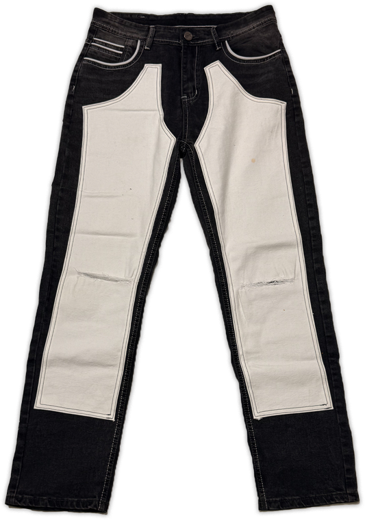 Black denim jeans with large off-white canvas panels on the front of the legs, photographed flat against a white background.