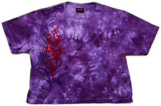 A purple tie-dye short-sleeve t-shirt featuring a red and purple floral graphic on the left side with black text reading 'Rise from the ashes”