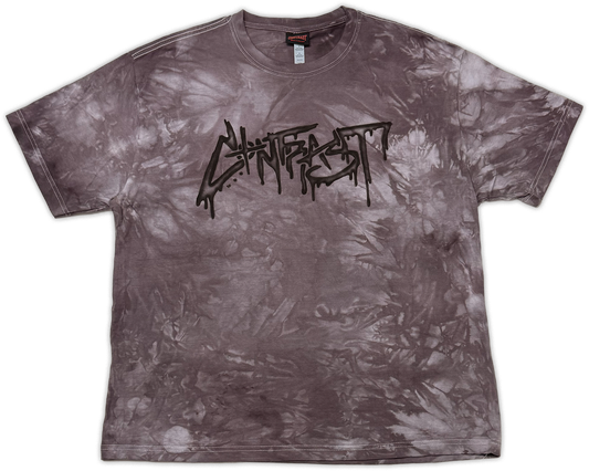 A short-sleeve crewneck t-shirt featuring a mottled, mineral-washed tie-dye pattern in dark gray and brownish tones, with a black 'contrast' band logo printed across the chest.