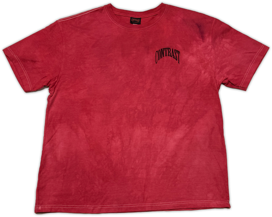 A red mineral-wash short-sleeve t-shirt with a black arched 'CONTRAST' logo printed on the left chest, displayed flat against a white background.