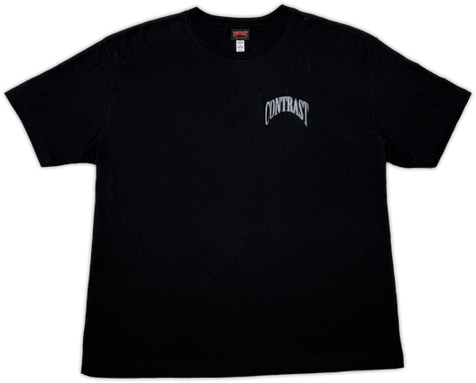 A black short-sleeve crewneck t-shirt with a white arched 'CONTRAST' logo printed on the left chest, displayed flat against a white background.