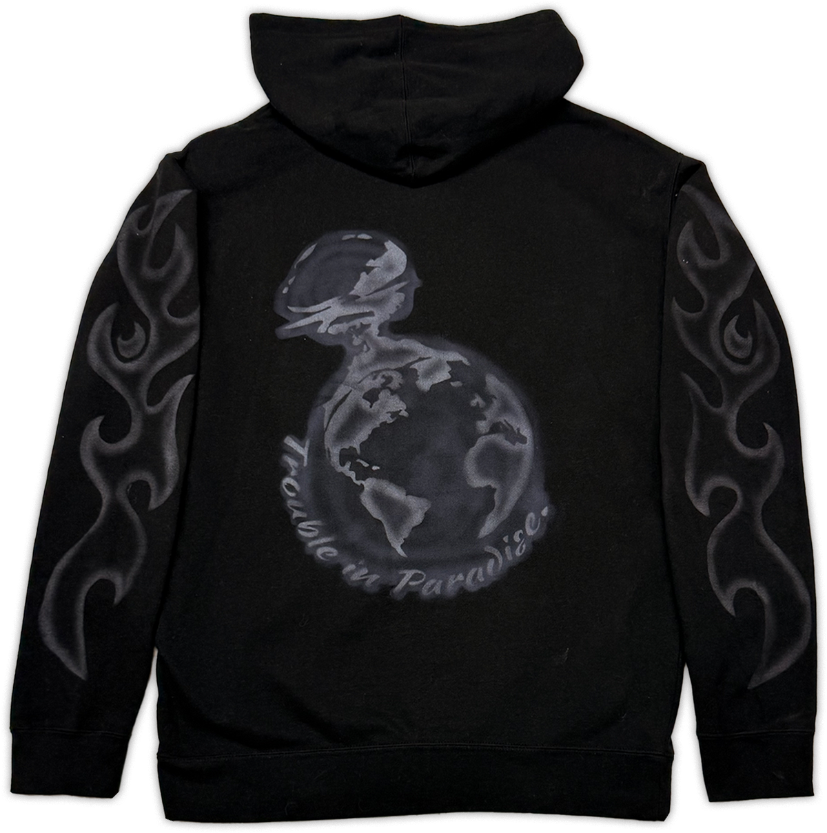 Black pullover hoodie shown from the back, featuring a large gray graphic of a globe with the words 'trouble in paradise' curved around it, plus gray flame-like sleeve prints.