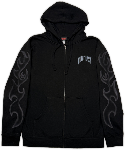 A black zip-up hoodie with a drawstring hood, kangaroo pocket, and gray flame-style graphics printed down both sleeves. The word 'CONTRAST' is printed in an arched gray font on the left chest.