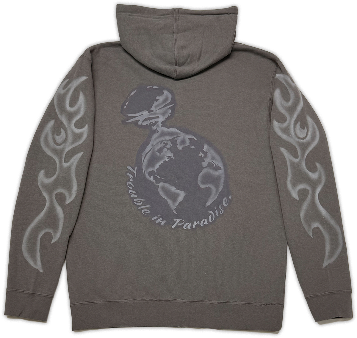 A dark gray zip-up hoodie shown from the back, featuring a large graphic of a globe, with the text 'trouble in Paradise' and silver flame designs on both sleeves.